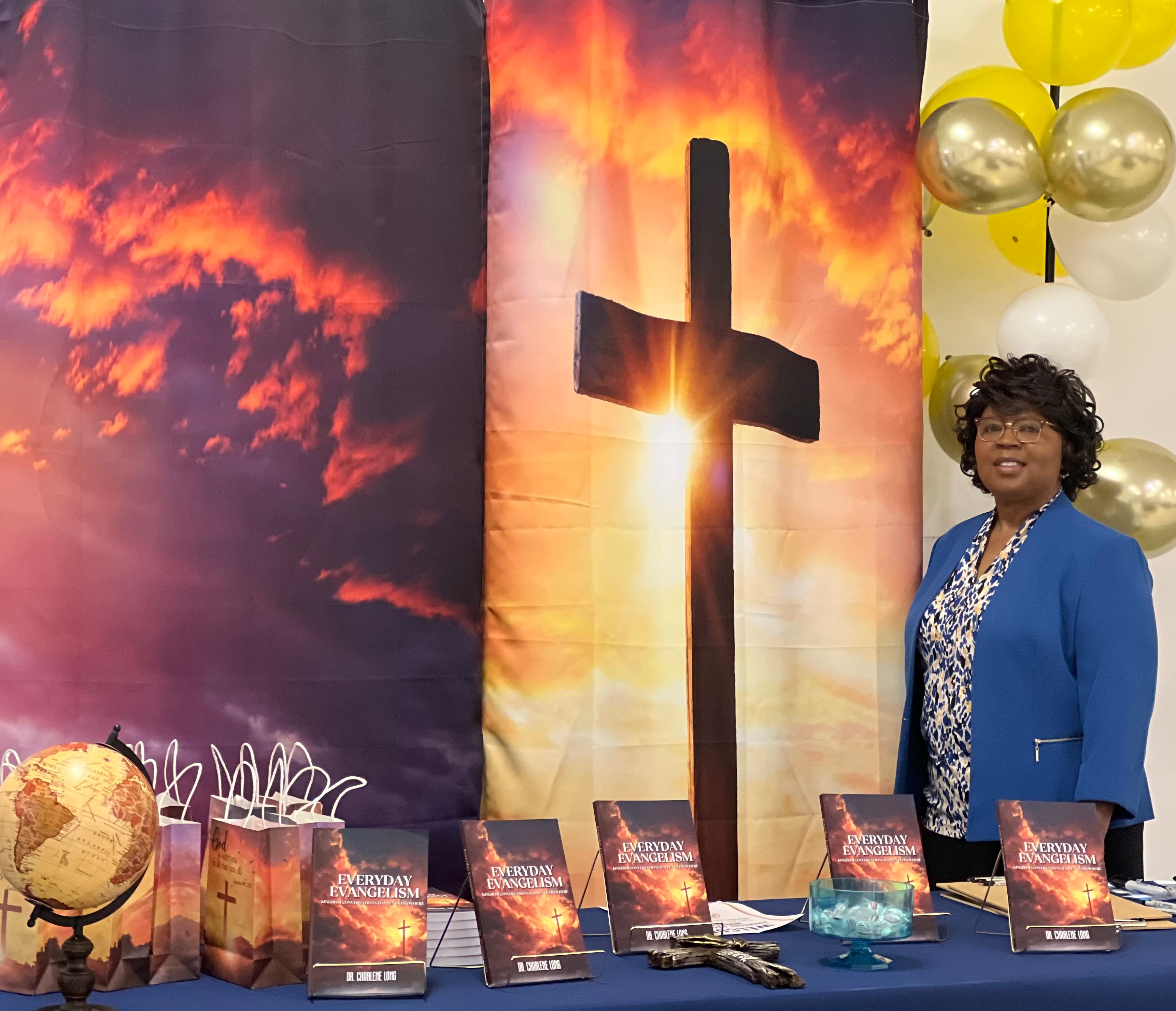 Everyday Evangelism book display with cross backdrop at ministry event