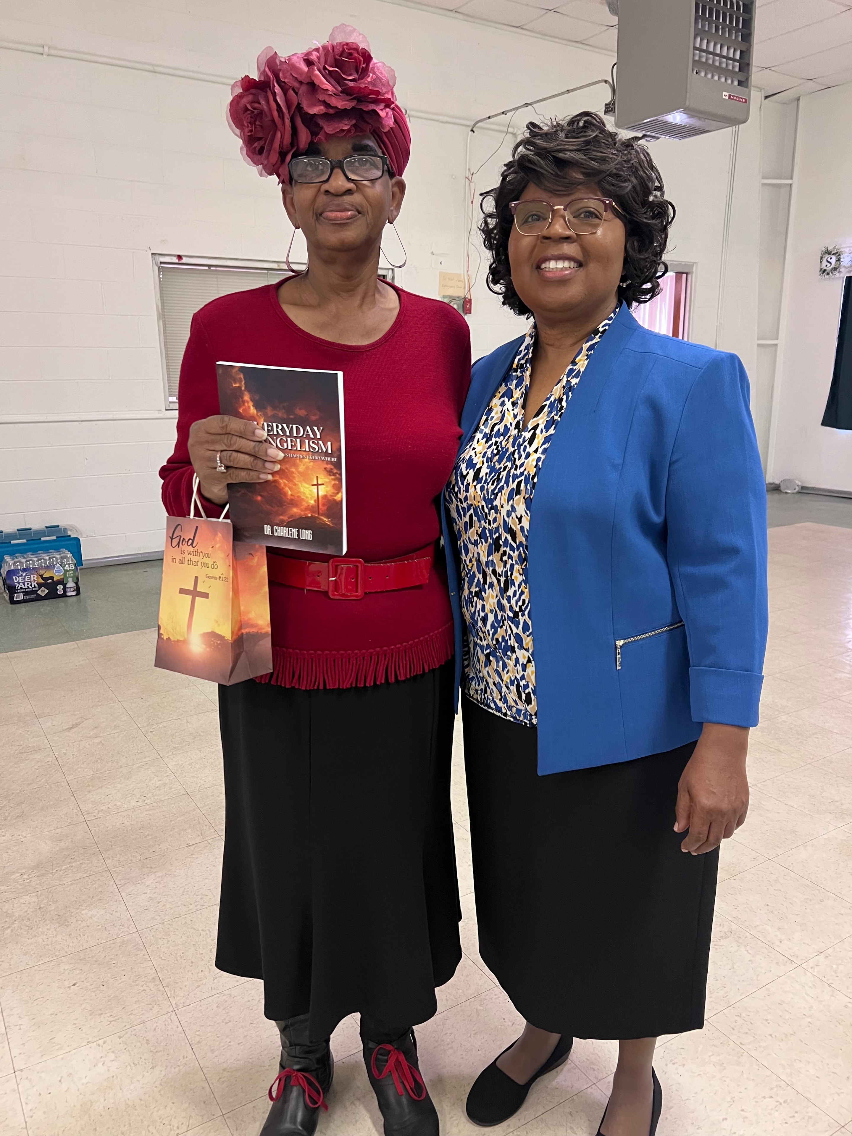 Ministry event — Dr. Charlene Long with a supporter holding Everyday Evangelism